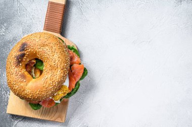 Tuzlu somonlu simit, krem peynir, avokado ve yumurta. Gri arka plan. Üst Manzara. Boşluğu kopyala.