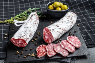 Fuet Salam dilimleri ve Rosemary. Geleneksel İspanyol sosisi. Siyah arka plan. Üst görünüm.