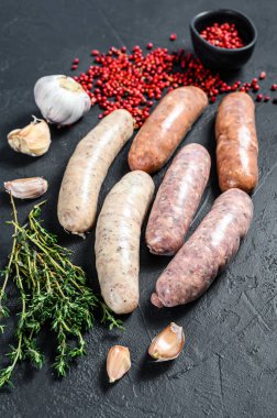 Kekik, sarımsak ve biberle çeşitli taze sosisler. Siyah arka plan. Üst görünüm.
