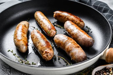 Izgara domuz eti, sığır eti ve tavada baharatlı tavuk sosisi. Gri arka plan. Üst görünüm.