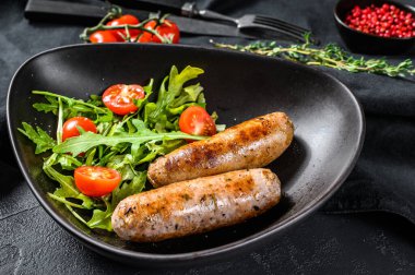 Domatesli ızgara sosis ve roka salatası. Barbekü et tarifi. Alman yemek tarifi. Siyah arka plan. Üst görünüm.