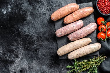 Baharatlı taze domuz eti, sığır eti ve tavuk sosisi. Siyah arka plan. Üst Manzara. Boşluğu kopyala.