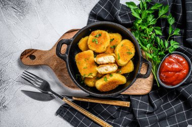 Ev yapımı tavuk nugget ve tavada ketçap sosu. Gri arka plan. Üst görünüm.