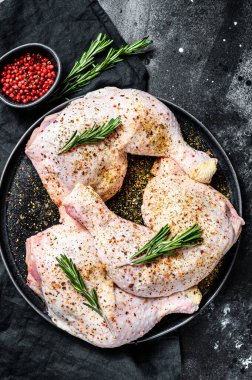 Taze çiğ tavuk butları, baharatlı bacaklar, yemek pişirme. Siyah arka plan. Üst görünüm.