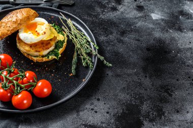 Balık fileto, yumurta ve ıspanaklı nefis balık burgeri. Siyah arka plan. Üst Manzara. Boşluğu kopyala.