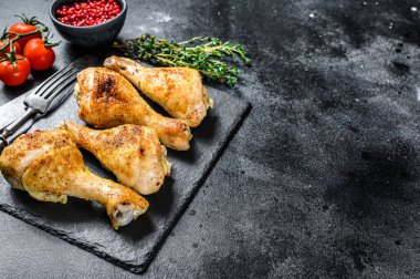 Fırında tavuk budu, otlu bacaklar. Siyah arka plan. Üst Manzara. Boşluğu kopyala.