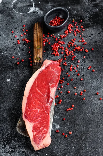 Raw marbled beef steak. black Angus meat. Black background. Top view.