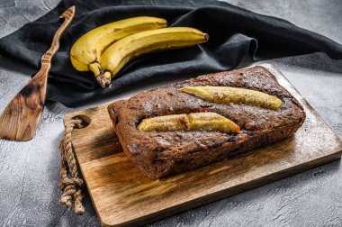 Cevizli ve çikolatalı taze pişmiş muzlu ekmek. Gri arka plan. Üst görünüm.