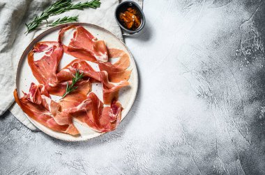 Prosciutto Crudo, İtalyan salamı, parma jambonu. Antipasto tabağı. Gri arkaplan, üst görünüm