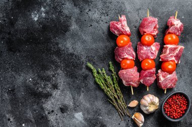 Çiğ domuz şiş kebap. Domates ve baharatlı barbekü eti. Siyah arka plan. Üst Manzara. Boşluğu kopyala.