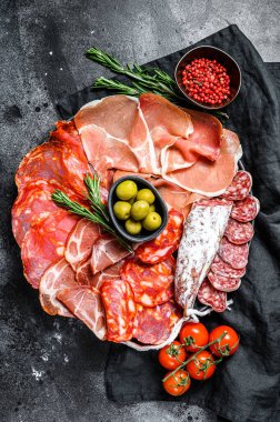 İspanyol soğuk et çeşitleri. Chorizo, fuet, LOMO, jamon Iberico, zeytin. Siyah arka plan. Üst görünüm
