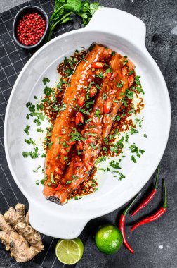 Teriyaki usulü alabalık pişiriyorum. Siyah arka plan. Üst görünüm.