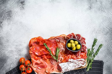 İspanyol soğuk et çeşitleri. Chorizo, fuet, LOMO, jamon Iberico, zeytin. Gri arka plan. Üst Manzara. Boşluğu kopyala.