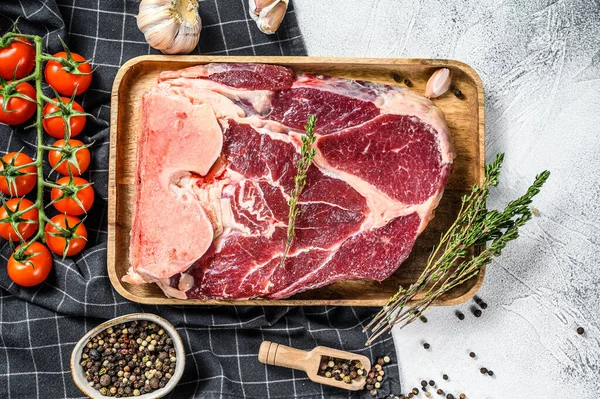 Raw fresh cross cut beef shank, leg with ingredients for cooking. Gray background. Top view.