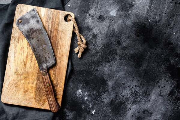 Vintage butcher meat cleaver on concrete board. Black background. Top view. Copy space.