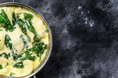 Ispanaklı omlet ve parmesan peyniri. Siyah arka plan. Üst Manzara. Boşluğu kopyala.