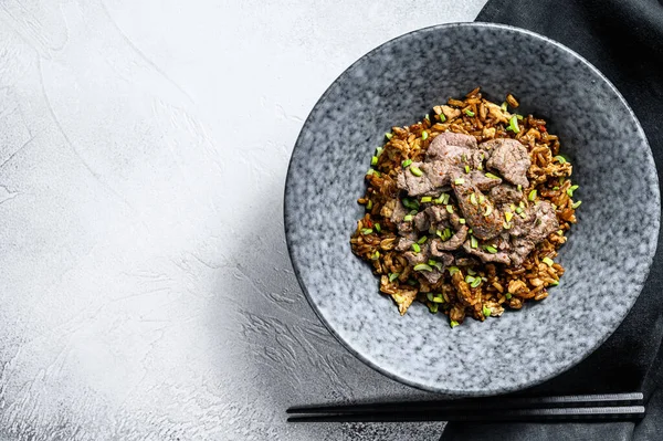 Biftek ve sebzeli özel kızarmış pilav. Beyaz arka plan. Üst Manzara. Boşluğu kopyala.