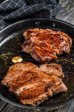 Tavada ızgara Chuck gözleme bifteği. Karanlık arka plan. Üst görünüm.