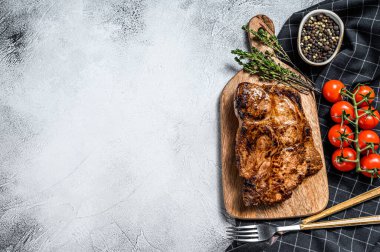 Doğrama tahtasında domuz eti kızartması. Organik et. Gri arka plan. Üst Manzara. Boşluğu kopyala.