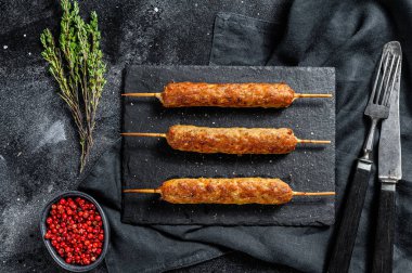 Lula kebabı. Çubukta şiş kebap, kıymalı kıymadan. Siyah arka plan. Üst görünüm.