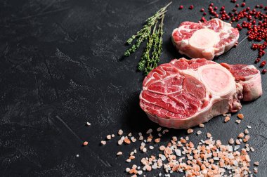 Çiğ dana şişi, Osso Buco baharat ve bitkilerle. OssoBuco eti. Siyah arka plan. Üst Manzara. Boşluğu kopyala.