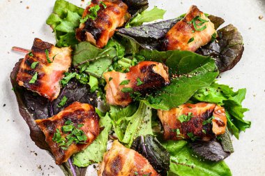 Doldurulmuş tavuk göğsü, domuz pastırması ve yeşil salata. Gri arka plan. Üst görünüm.