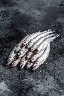 Taze çiğ deniz küçük balıklar kokar. Siyah arka plan. Üst görünüm.