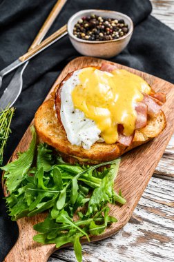 Pastırmalı Brioche sandviç, Benedict usulü yumurta ve Hollandaise sosu. Beyaz arka plan. Üst görünüm.
