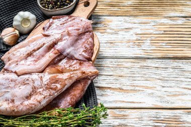 Çiğ mürekkep balığı ve malzemelerin hazırlanması. Beyaz ahşap arka plan. Üst Manzara. Boşluğu kopyala.