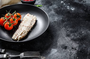 Çeri domatesli buğulanmış morina filetosu. Siyah arka plan. Üst Manzara. Boşluğu kopyala.