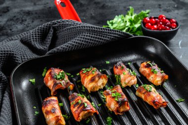 Tavaya sarılmış pastırmalı tavuk göğsü. Siyah arka plan. Üst görünüm.