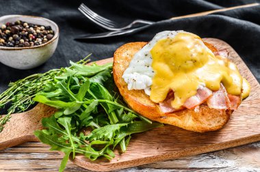 Pastırmalı Brioche sandviç, Benedict usulü yumurta ve Hollandaise sosu. Beyaz arka plan. Üst görünüm.