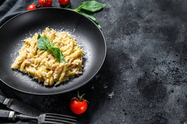 Krema soslu orzo makarna, pastırma ve fesleğen. Hazır risoni. Siyah arka plan. Üst Manzara. Boşluğu kopyala.