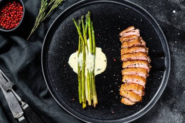 Karamelli kuşkonmaz ile sulu ördek göğsü bifteği. Siyah arka plan. Üst görünüm.