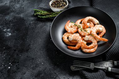 Soyulmuş kral karidesleri, tabakta karidesler. Siyah arka plan. Üst Manzara. Boşluğu kopyala.