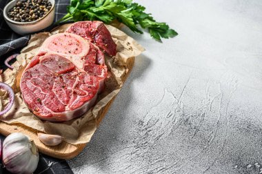 Çiğ dana şişi, Osso Buco baharat ve bitkilerle. OssoBuco eti. Gri arka plan. Üst Manzara. Boşluğu kopyala.