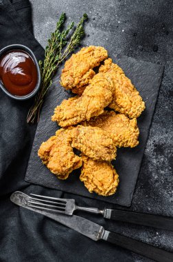 Kızarmış tavuk, patates kızartması ve domates. Siyah arka plan. Üst görünüm.