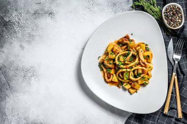 Mürekkep balığı, patates ve domatesli yahni. İtalyan mutfağı. Beyaz arka plan. Üst Manzara. Boşluğu kopyala.