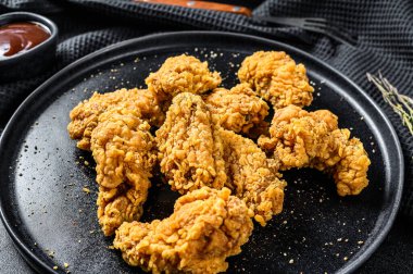 Siyah tabakta kızarmış tavuk kanadı. Siyah arka plan. Üst görünüm.