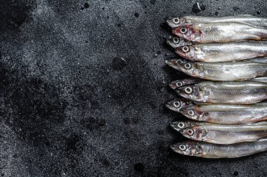 Taze çiğ deniz küçük balıklar kokar. Siyah arka plan. Üst Manzara. Boşluğu kopyala.