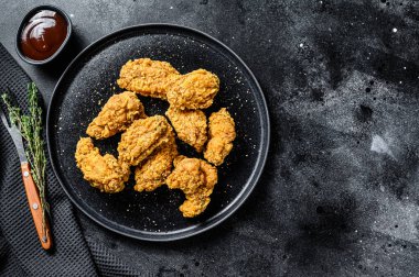 Siyah tabakta kızarmış tavuk kanadı. Siyah arka plan. Üst Manzara. Boşluğu kopyala.