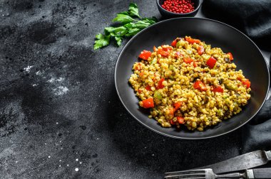 Sebzeli ve etli bulgur. Siyah arka plan. Üst Manzara. Boşluğu kopyala.