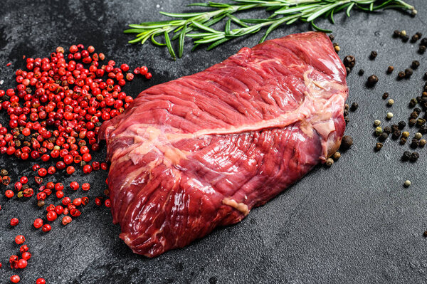 Top blade steak, raw meat, marbled beef . Black background. Top view.