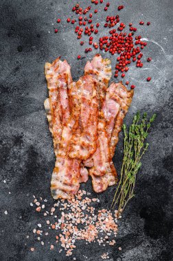 Kavrulmuş çıtır çıtır domuz pastırması. Siyah arka plan. Üst görünüm.