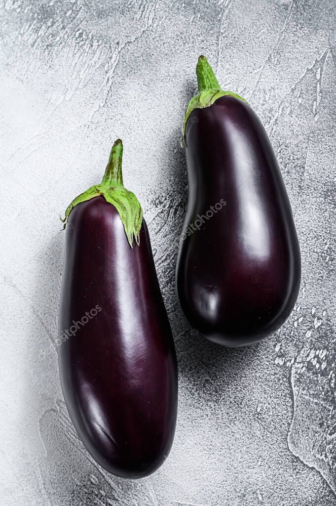 Raw purple eggplant. Organic vegetables. Gray background. Top view.