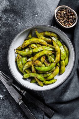 Kızarmış yeşil edamame soya fasulyesi, Japon yemeği. Siyah arka plan. Üst görünüm.