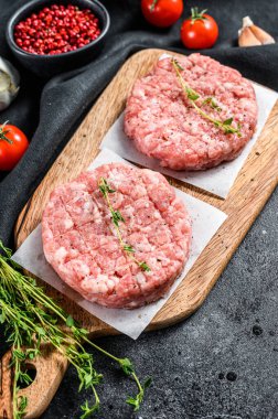 Çiğ domuz pirzolası, kıymalı börek. Organik kıyma. Siyah arka plan. Üst görünüm.