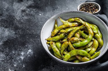 Kızarmış yeşil edamame soya fasulyesi, Japon yemeği. Siyah arka plan. Üst Manzara. Boşluğu kopyala.