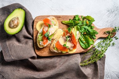 Avokado ve füme somon ile tost. Beyaz arka plan. Üst görünüm.