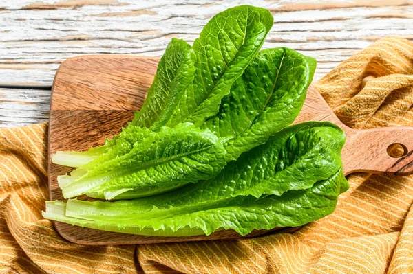 Kesme tahtasında romaine marul salatası. Beyaz arka plan. Üst görünüm.